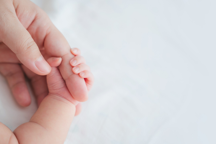 Photo shows a mother holding her newborn baby's hand/Getty Images