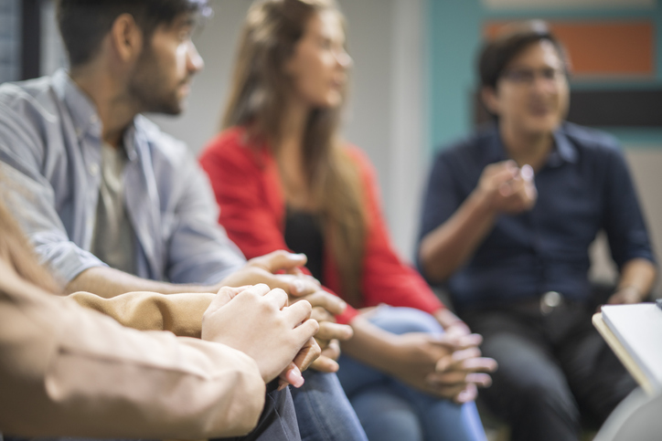 Photo shows young people in a support group gathering for a meeting/Getty Images