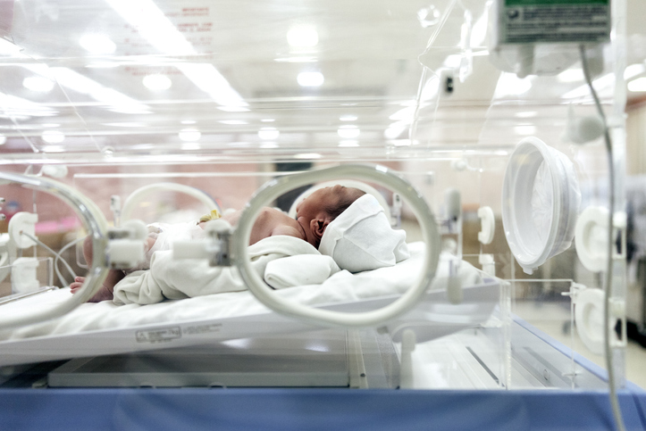 Photo shows newborn baby lying in a hospital bed/Getty Images