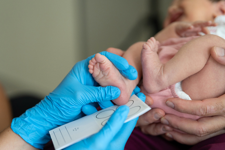 Photo shows a doctor measuring the foot of a newborn baby in the hospital/Getty Images