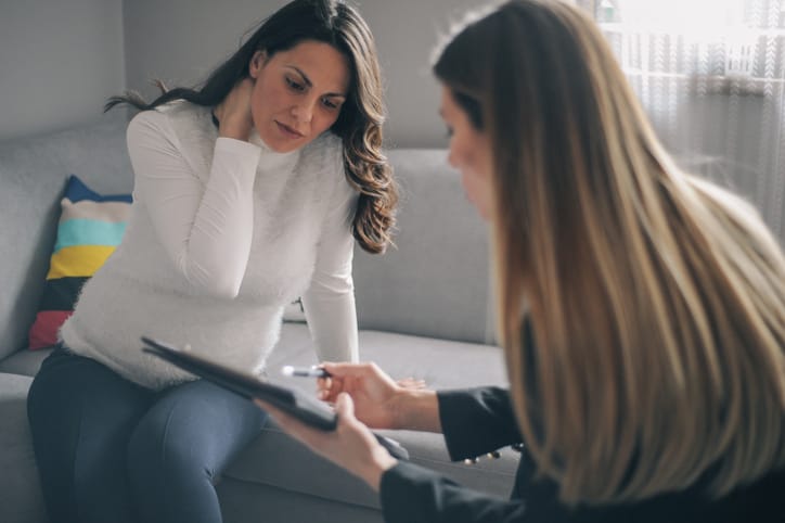 Photo shows a pregnant woman meeting with a counselor in her home/Getty Images