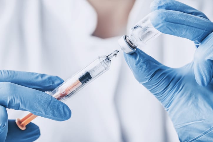 Photo shows a doctor preparing a syringe for an injection/Getty Images