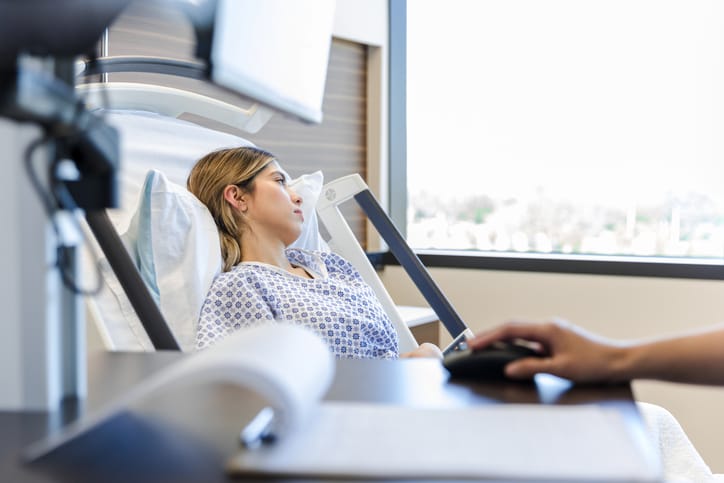 Photo shows a patient in a hospital bed gazing out of the window/Getty Images
