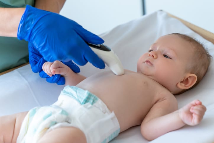 Photo shows a doctor measuring a baby's temperature/Getty Images