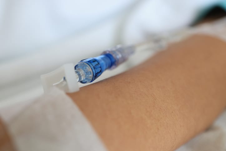 Photo shows a close-up shot of a patient arm receiving fluids/Getty Images