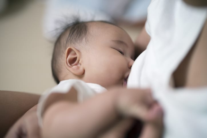 Photo shows a mother breastfeeding a baby boy while sitting at home/Getty Images