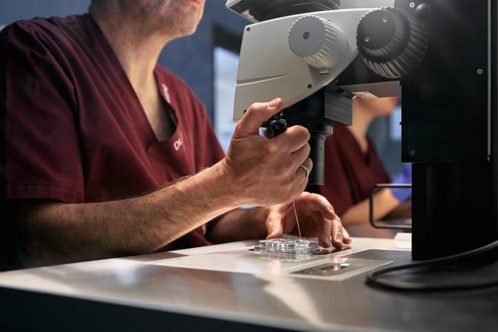 Photo shows a doctor analyzing cell samples in a clinical fertility laboratory