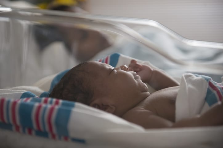 Photo shows a newborn baby sleeping in a crib in the hospital/Getty Images
