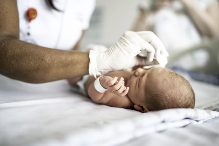 Photo shows a nurse cleaning a newborn at a hospital/Getty Images