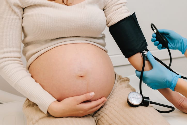 A doctor takes a pregnant woman's blood pressure/Getty Images