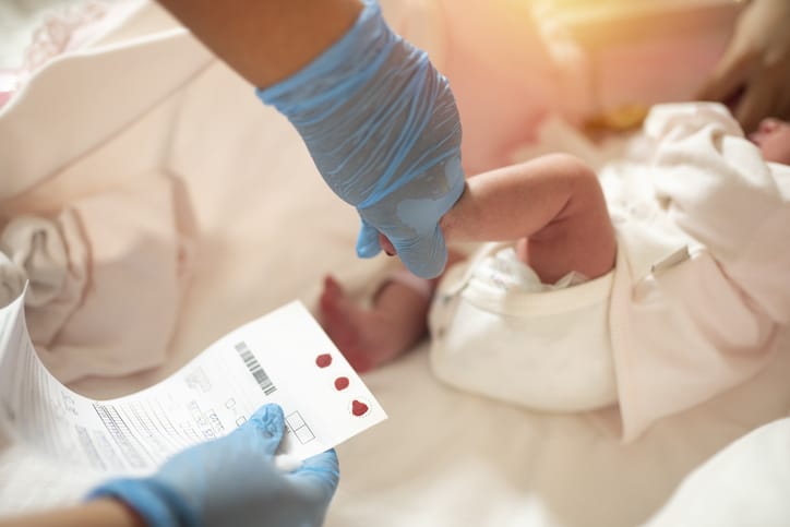Photo shows a newborn's blood being tested via a heel prick/Getty Images