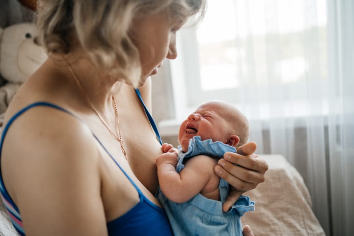 Photo shows a mother holding her crying newborn/Getty Images