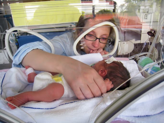 Photo shows a mother visiting her premature newborn in the NICU/Getty Images