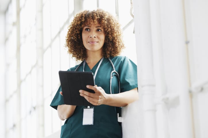 Photo shows a healthcare worker holding a digital tablet in a hospital/Getty Images