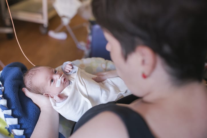 Photo shows a mother holding her infant in the NICU/Getty Images