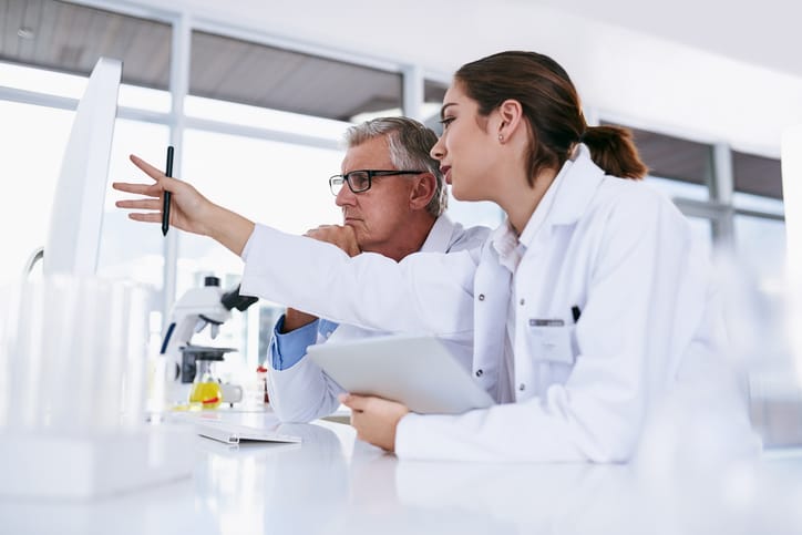 Photo shows two scientists talking in a lab (Getty Images/PeopleImages)