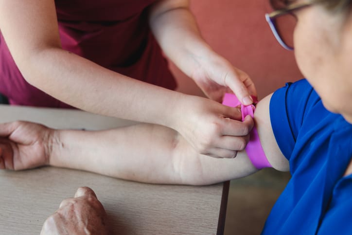 Photo shows a nurse applying a tourniquet to a woman's arm/Getty Images