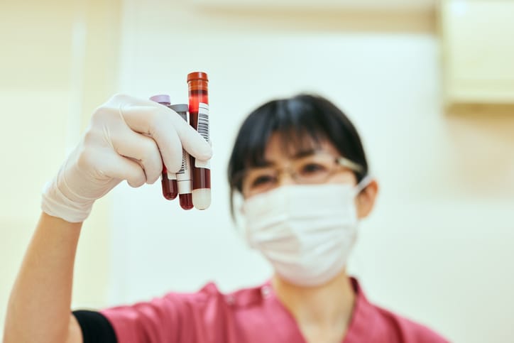 Photo shows a nurse holding blood samples from patients/Getty Images/Yoshiyoshi Hirokawa