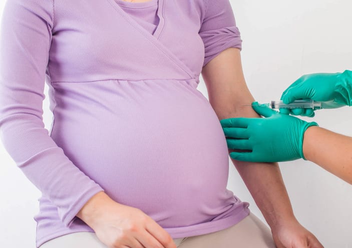 Photo shows a doctor taking a biochemical blood test from a pregnant woman/Getty Images/Henadzi Pechan