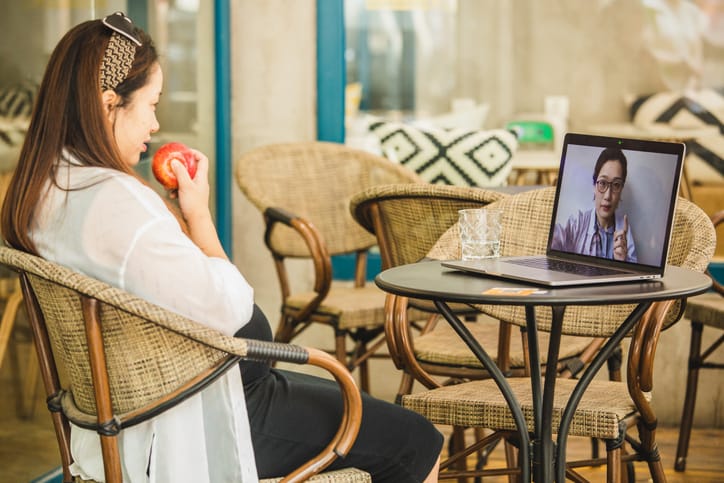 Photo shows a pregnant woman attending a telehealth appointment at home (Getty Images/Kilito Chan)